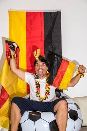 Euphorischer Fußballfan schaut euphorisch Deutschlandspiel auf Fernseher