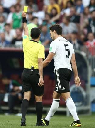 MOSCOW, RUSSIA - JUNE 17, 2018: Referee Alireza Faghani (L) shows the yellow card to Germany s Mats Hummels in the 2018 FIFA World Cup WM Weltmeisterschaft Fussball Group F football match against Mexico at Luzhniki Stadium. Mexico won the game 1-0. Valery Sharifulin TASS  TS084C99