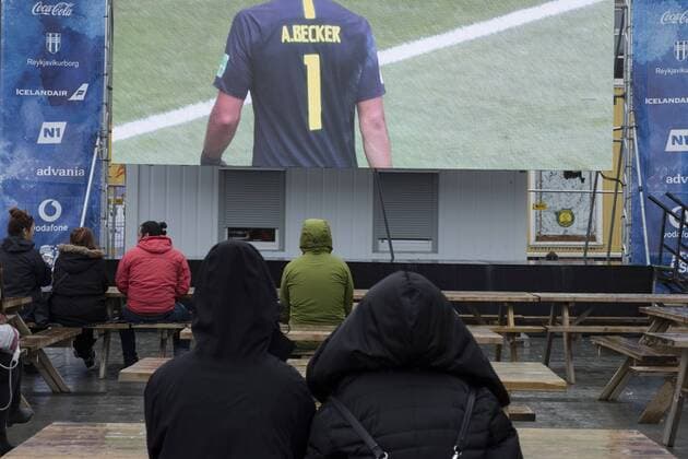 Nur wenige Fußballfans verfolgen im Dauerregen das Achtelfinalspiel Mexiko gegen Brasilien anlässlich der FIFA Fussball-Weltmeisterschaft am Ingólfstorg in Reykjavik FIFA World-Cup 2018 - Public Viewing in Reykjavik