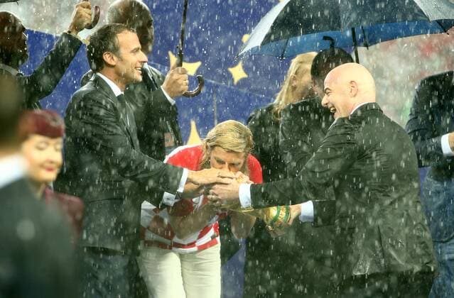 Präsident Emmanuel Macron, Präsidentin Kolinda Grabar Kitarovic, FIFA Präsident Gianni Infantino mit WM Pokal im strömenden Regen Fußball Fussball FIFA WM Weltmeisterschaft Russland Russia 2018 Finale Saison 2017 2018 15.07.2018 Frankreich FRA vs. Kroatien CRO