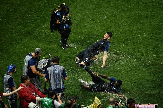 Fußball, WM Finale 2018 in Moskau, Frankreich - Kroatien Blaise Matuidi, front, and Olivier Giroud of France slide on the lawn to celebrate after France defeated Croatia in their final match during the 2018 FIFA World Cup WM Weltmeisterschaft Fussball in Moscow, Russia, 15 July 2018. France slashes Croatia to win World Cup for second time  20180716_43490