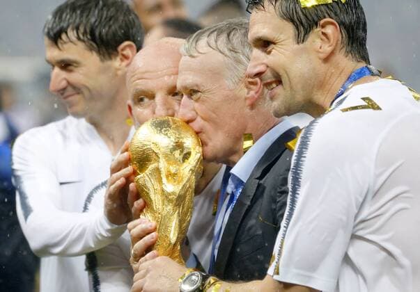 Football: World Cup final France coach Didier Deschamps (2nd from R) kisses the World Cup trophy after his team defeated Croatia 4-2 to win the country s second World Cup title at Luzhniki Stadium in Moscow on July 15, 2018. 