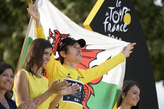 British Geraint Thomas of Team Sky wearing the yellow jersey of overall leader, carrying a Welsh flag, celebrates on the podium after the last stage of the 105th edition of the Tour de France cycling race, 116km from Houilles to Paris, France, Sunday 29 July 2018. This year s Tour de France takes place from July 7th to July 29th. YORICKxJANSENS  x05395078x