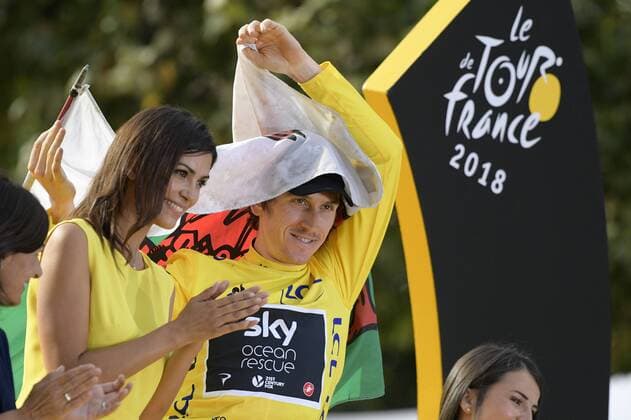 British Geraint Thomas of Team Sky wearing the yellow jersey of overall leader, carrying a Welsh flag, celebrates on the podium after the last stage of the 105th edition of the Tour de France cycling race, 116km from Houilles to Paris, France, Sunday 29 July 2018. This year s Tour de France takes place from July 7th to July 29th. YORICKxJANSENS  x05395079x