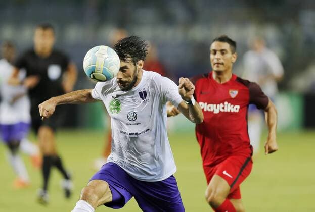 BUDAPEST, HUNGARY - AUGUST 2: (l-r) Mijusko Bojovic of Ujpest FC heads the ball in front of Wissam Ben Yedder of Sevilla FC during the UEFA Europa League Second Qualifying Round 2nd Leg match between Ujpest FC and Sevilla FC at Ferenc Szusza Stadium on August 2, 2018 in Budapest, Hungary. LaszloxSzirtesi 