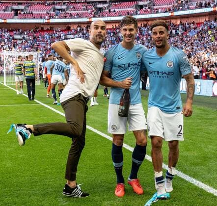 Pep Guardiola manager of Manchester City celebrates victory with John Stones and Kyle Walker during the 2018 FA Community Shield match between Chelsea and Manchester City at Wembley Stadium, London, England on 5 August 2018. Copyright: xLiamxMcAvoyx 20580084
