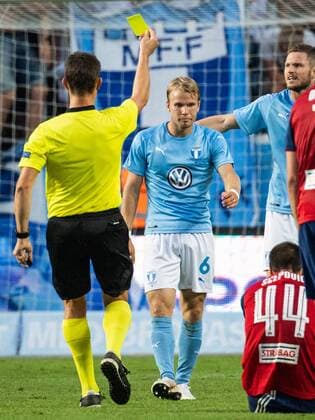 180807 Referee Matej Jug gives a yellow card to Oscar Lewicki of Malmö FF during the UEFA Champions League qualifying match between Malmö FF and Vidi on August 7, 2018 in Malmö. Photo: Ludvig Thunman BILDBYRAN kod LT 35513 Copyright: LUDVIGxTHUNMAN BB180807LT090
