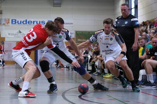 Handball Sportverein Hamburg - SC DHfK Leipzig, Handball, Internationaler Heide-Cup 2018, 11.08.18 Alen Milosevic (Nr.34, SC DHfK Leipzig) haelt Jan Forstbauer (Nr.23, Handball Verein Hamburg) in Schach bis Teamkollege Patrick Wiesmach (Nr.04, SC DHfK Leipzig). Unter den Auge von Michael Biegler (SC DHfK Leipzig, Trainer)