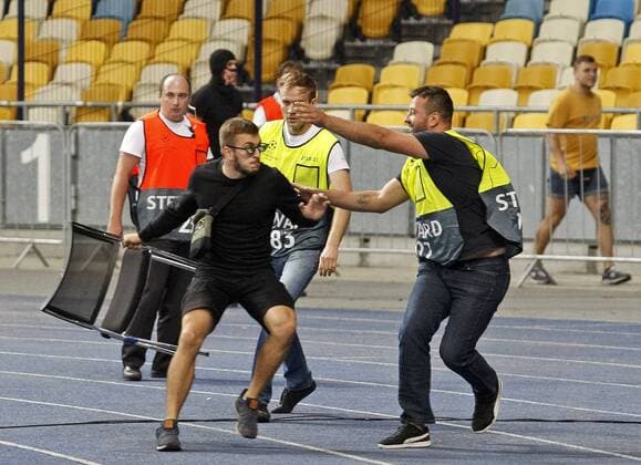 August 28, 2018 - Kiev, Ukraine - Stewards try to stop a football hooligans throwing chairs to side of Ajax fans before begining the UEFA Champions League play-off, second leg soccer match between Ajax Amsterdam and FC Dynamo Kyiv, on the NSC Olimpiyskiy stadium in Kiev, Ukraine, 28 August,2018. Dinamo Kiev v Ajax - UEFA Champions League  - ZUMAn230 20180828_zaa_n230_372 Copyright: xStrx