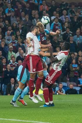 Burnley v Olympiakos F.C. UEFA Europa League Ben Mee of Burnley in an aerial challenge with Konstantinos Tsimikas (left) and Mady Camara of Olympiakos (right) during the UEFA Europa League match at Turf Moor, Burnley Content Not Available For UK Newspapers Copyright: xMattxWilkinsonx FIL-12218-0020