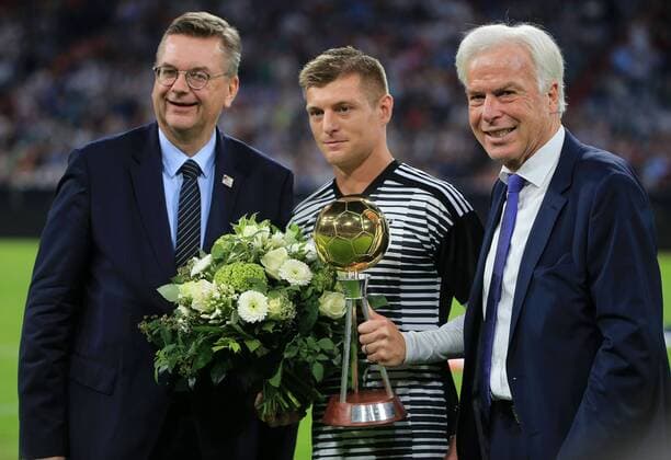 06.09.2018,UEFA Nations League, Deutschland vs Frankreich, Allianz Arena Muenchen, Fussball, im Bild: DFB Praesident Grindel und Kicker Chef erreichen das Pokal fuer der beste Deutsche Fussbal Spiel Toni Kroos DFL REGULATIONS PROHIBIT ANY USE OF PHOTOGRAPHS AS IMAGE SEQUENCES AND OR QUASI VIDEO.