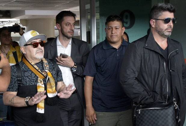 (180909) -- SINALOA, Sept. 9, 2018 -- Argentine football legend Diego Maradona (L) reacts upon his arrival at the airport in Culiacan, state of Sinaloa, Mexico, on Sept. 8, 2018. Maradona arrived in northern Mexico to begin his new job as the head coach of the second-tier Mexican soccer club Dorados of Sinaloa. Juan Carlos Cruz) (cr) (SP)MEXICO-SINALOA-MARADONA-ARRIVAL e JUANxCARLOSxCRUZ 