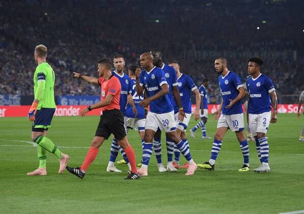 18.09.2018, Fussball, UEFA Champions League, Saison 2018 2019, Vorrunde, 1. Spieltag, FC Schalke 04 - FC Porto, Handelfmeter für Porto, Schiedsrichter Jesus Gil Manzano (ESP) wird von den Schalker Spielern umringt, rechts daneben Naldo (FC Schalke 04)
