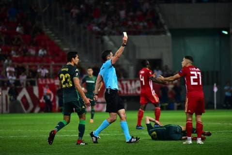 UEFA Europa League: Olympiacos vs Betis Referee is pointed out to Kostas Tsimikas (no 21) of Olympiacos the yellow card. Piraeus Attiki Greece Stadio Georgios Karaiskakis  DimitriosxKarvountzis PacificxPress