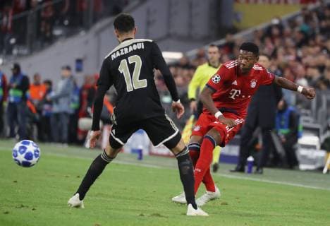 Champions League Spiel FC Bayern München - Ajax Amsterdam 1 : 1 David Alaba schiesst, Noussair Mazraoui schaut zu DFL regulations prohibit any use of photographs as image sequences and or quasi-video. München Bayern Deutschland Allianz Arena