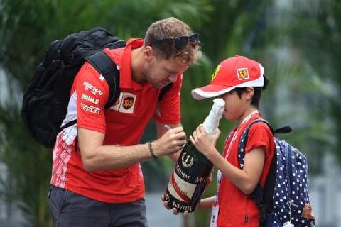 Sport Bilder des Tages 5th October 2018, Suzuka International Racing Course, Suzuka City, Japan; Formula One Grand Prix of Japan, Friday free practice; Sebastian Vettel signs a champagne bottle for a child  ActionPlus12068105 Octane