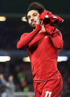 11th December 2018, Anfield, Liverpool, England; UEFA Champions League football, Liverpool versus Napoli; Mohamed Salah of Liverpool takes of his shirt to present to a fan on the Kop after the final whistle  ActionPlus12086872 DavidxBlunsden