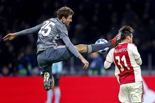 AMSTERDAM, Ajax - Bayern Munchen, football, Champions League Season 2018 2019, 12-12-2018, Johan Cruijff Arena . Bayern Munchen player Thomas Muller (L) with an karate kick to Ajax player Nicolas Tagliafico (R) during the game Ajax - Bayern . Ajax - Bayern  x2686512x
