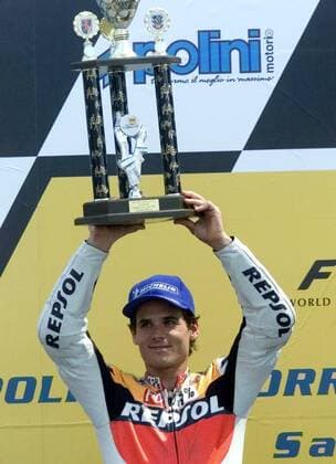 Spanish rider Alex Criville presents during winner ceremony his trophy to the crowd. Criville placed second during the 500cc race of German motor cycling Grand Prix at the Sachsenring circuit Sunday, July 18, 1999. U.S. rider Kenny Roberts junior wons the race and Japanese rider Norick Abe placed third. ( Eckehard Schulz) SACHSENRING DEU