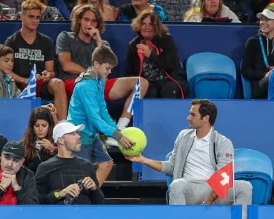 Roger Federer sitzt in der Spielerloge undschreibt ein Autogramm fuer einen Jungen aus dem Stefanos Tsitsipas Team Copyright: xJuergenxHasenkopfx