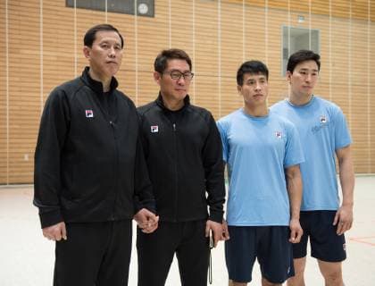 Trainer Myong Chol Sin, Cheftrainer Young Shin Cho, der suedkoreanische Spieler und Kapitaen Suyoung Jung, sowie der nordkoreanische Spieler Song Jin Ri (l-r) posieren fuer ein Foto. Trainer Myong Chol Sin und Cheftrainer Young Shin Cho halten dabei gemeinsam die Hand. Handball Oeffentliches Training der gemeinsamen Handballmannschaft aus Nord- und Suedkorea in Vorbereitung auf die Handball Weltmeisterschaft 2019 in DEN GER im Horst-Kober Sportzentrum in Berlin, Deutschland am 04.01.2019,