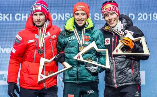 22.02.2019, Medal Plaza, Seefeld, AUT, FIS Weltmeisterschaften Ski Nordisch, Seefeld 2019, Nordische Kombination, Siegerehrung, im Bild v.l.: Silbermedaillengewinner Jan Schmid (NOR), Weltmeister und Goldmedaillengewinner Eric Frenzel (GER), Bronzemedaillengewinner Franz Josef Rehrl (AUT) f.l.: Silver medalist Jan Schmid of Norway World champion and gold medalist Eric Frenzel of Germany Bronze medalist Franz Josef Rehrl of Austria during the winner Ceremony for the Nordic Combined competition of FIS Nordic Ski World Championships 2019 at the Medal Plaza in Seefeld, Austria on 2019 02 22. Seefeld