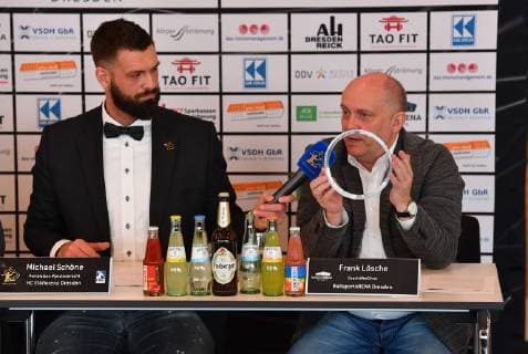 von rechts: Frank Lösche zeigt einen der Bodendeckel, daneben: Michael Schöne, Pressekonferenz wegen des Urteils nach dem Spielabbruch HC Elbflorenz Dresden gegen , Handball, 2. Liga der Männer, 2. Bundesliga, Saison 2018 2019, Dresden, BallsportARENA Dresden,