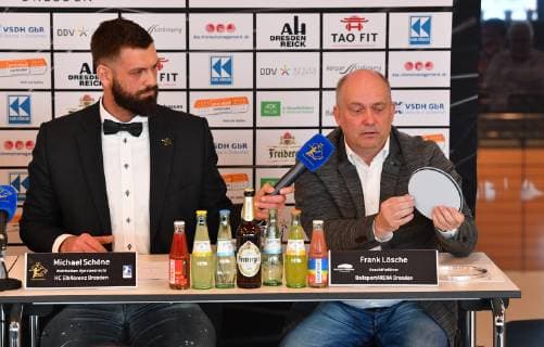 von rechts: Frank Lösche zeigt einen der Bodendeckel, daneben: Michael Schöne, Pressekonferenz wegen des Urteils nach dem Spielabbruch HC Elbflorenz Dresden gegen , Handball, 2. Liga der Männer, 2. Bundesliga, Saison 2018 2019, Dresden, BallsportARENA Dresden,