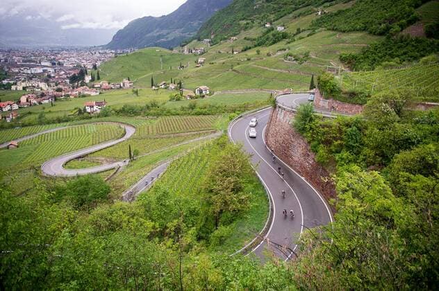 Das Fahrerfeld Peloton waehrend der 5.Etappe der Tour of the Alps 2019 - hier in der Abfahrt von Klobenstein - Landschaft - Landscape - Feature - Natur - Hintergrund - Illustration - Impression - Uebersichtsbild - kompaktes Fahrerfeld - Aktion Rennszene - Querformat - quer - horizontal - Event Veranstaltung: 43. Tour of the Alps - 5.Etappe Stage 5: Caldaro Kaltern to Bolzano Bozen 147.8 km - Ort Location: Bozen - Region: Trentino - Land Country: Italien Italy - Datum Date: 26.04.2019 Cycling Radsport 43. Tour of the Alps - 5.Etappe 26.04.2019
