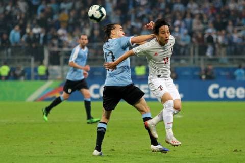 20th June 2019, Arena do Gremio, Porto Alegre, Brazil. Copa America international football, Uruguay versus Japan; Diego Laxalt of Uruguay and Koji Miyoshi of Japan challenge for the crossed ball  ActionPlus12146037 MaxxPeixoto