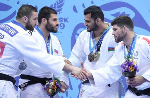MINSK, BELARUS - JUNE 24, 2019: Athletes Varlam Liparteliani of Georgia, Arman Adamian of Russia, Elmar Gasimov of Azerbaijan and Cyrille Maret (L-R) of France shake hands at a victory ceremony after the men s haf-heavy weight (-100kg) gold medal bout at the 2nd Europaspiele Natalia Fedosenko TASS  TS0B0C5E