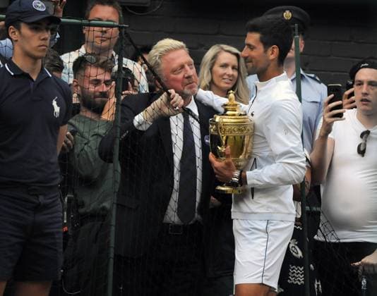 Sport Bilder des Tages Tennis - 2019 Wimbledon Championships - Week Two, Sunday (Day Thirteen) Men s Singles, Final: Novak Djokovic (SRB) vs. Roger Federer (SUI) Boris Becker catches a quick word with winner Novak Djokovic on his lap of honour, on Centre Court. COLORSPORT ANDREW COWIE 