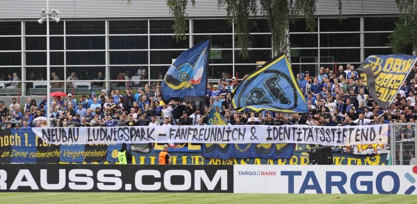 Fußball, Stadiongeschichte 1. FC Saarbrücken 11.08.2019, xklex, Fussball Regionalliga Suedwest, 1.FC Saarbruecken - Jahn Regensburg emspor, v.l. Die Fans des 1.FC Saarbrücken mit einem Spruchbanner (DFL DFB REGULATIONS PROHIBIT ANY USE OF PHOTOGRAPHS as IMAGE SEQUENCES and or QUASI-VIDEO) Voelklingen