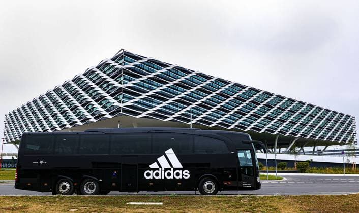 Adidas Bus vor der Arena; Adidas Arena, Verwaltungsgebaeude (Verwaltungsgebäude) der adidas AG das an eine Fussballarena, Fussballstadion erinnert, ist 52.000 qm gross und bietet mehr als 2.000 Mitarbeitern Platz; ist Teil der ãWorld of SportsÒ; Herzogenaurach am 29.07.2019;