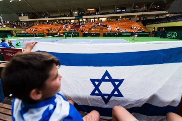 2019 Davis Cup Sweden v Israel 190913 A young spectator with an Israeli flag i seen in the foreground of Edan Leshem of Israel during the Davis Cup qualification tennis match between Sweden and Israel on September 13, 2019 in Stockholm. Copyright: JOHANNAxLUNDBERG BB190913JL013