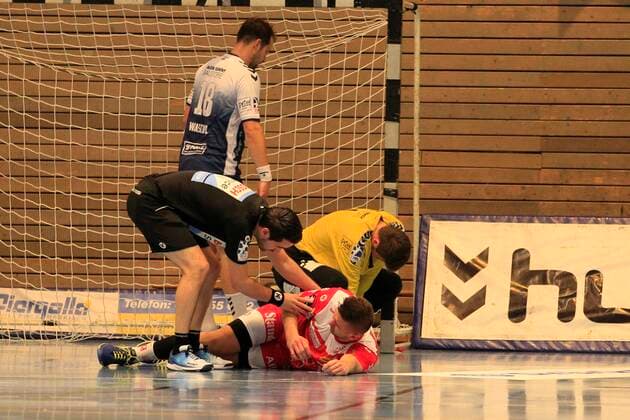 2.Bundesliga Handball VfL Luebeck-Schwartau - TUSEM Essen 20.10.2019, Hansehalle Luebeck, GER, 2.Bundesliga Handball VfL Luebeck-Schwartau - TUSEM Essen im Bild picture shows Verletzt Verletzung Schmerzen. Dennis Szczesny (TUSEM Essen) liegt nach einem Zusammenstoss mit Torwart Marino Mallwitz VfL Luebeck-Schwartau am Boden, links Schiedsrichter Kim von der Beeck