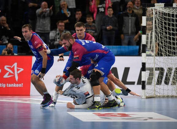 Drei Mann stürzen sich auf Hendrik Pekeler (THW Kiel), Handball, Männer, THW Kiel vs HC Motor Saporischja (Zaporozhye), Champions-League, 9. Spieltag, Gruppenphase, 20.11.19 Kiel Sparkassen-Arena Schleswig-Holstein Germany