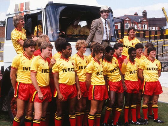 Football - 1982 1983 Season - Watford Photocall Watford Chairman Elton John and the Watford team pose with a truck from new sponsors Iveco, at Vicarage Road. Front row includes Steve Sims, Kenny Jackett, John Barnes, Pat Rice. The industrial vehicle manufacturer were the club s first shirt sponsors in a Â£400,000 three-year deal. 