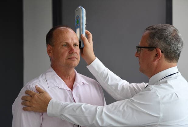 Bilder des Jahres 2019, Sport 12 Dezember Sport Themen der Woche KW49 MEDICAL CONCUSSION TEST, Boxing trainer Noel Thornberry (left) is being scanned for bleeding on the brain by Yosef Ben Dor with the Infrascan handheld device during a demonstration to the media in Brisbane, Tuesday, December 3, 2019. NRL chief medical officer Dr Paul Bloomfield will meet with Thornberry next week to discuss the use of the portable scanner that will detect bleeding on the brain on the spot and complement on-field HIA tests. ( NO ARCHIVING, EDITORIAL USE ONLY, NO USE IN BOOKS WITHOUT CONSENT BRISBANE QLD AUSTRALIA  Copyright: xDANxPELEDx 20191203001435843189