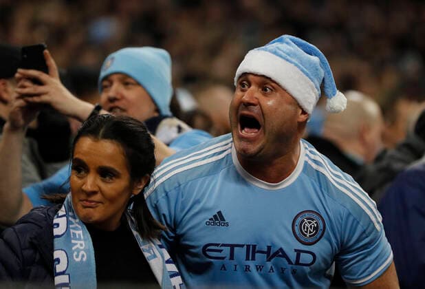 A Manchester City fan celebrates during the Premier League match at the Etihad Stadium, Manchester. Picture date: 21st December 2019. Picture credit should read: Darren Staples Sportimage EDITORIAL USE ONLY. No use with unauthorised audio, video, data, fixture lists, club league logos or live services. Online in-match use limited to 120 images, no video emulation. No use in betting, games or single club league player publications. SPI-0391-0013