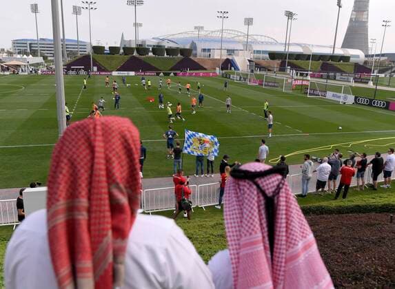 05.01.2020, Fussball 1. Bundesliga 2019 2020, FC Bayern München im Wintertrainingslager in Doha, Katar. 1. Trainingseinheit in der Aspire Academy, Übersicht vom Trainingsplatz. Einheimische Zuschauer am Rand. Unten weht die Bayernflagge eines stolzen Bayern-Fans.