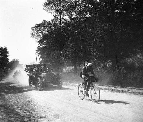 FABER Francois Francois FABER (DEBUT 20 S.), le futur vainqueur du Tour de France de 1909, suivi de la voiture suiveuse Alcyon, de sa marque. Photographie d amateur. Credit : Jean Vigne KHARBINE-TAPABOR.