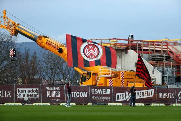 Fußball, Stadiongeschichte SV Wehen Wiesbaden Eine Fahne des SV Wehen Wiesbaden vor einem Bagger auf der Stadionbaustelle der Brita-Arena SV Wehen Wiesbaden vs VfL Bochum, Fussball, 2. Liga, 09.02.2020 DFL REGULATIONS PROHIBIT ANY USE OF PHOTOGRAPHS AS IMAGE SEQUENCES AND OR QUASI-VIDEO SV Wehen Wiesbaden vs VfL Bochum, Fussball, 2. Liga, 09.02.2020 Wiesbaden Copyright: xWeissx Eibner-Pressefotox EP_rws