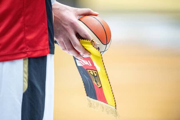 Ein deutscher Spieler haelt den Wimpel und einen kleinen Basketball in den Haenden, Feature, allgemein, Randmotiv, Basketball EM-Qualifikation, Gruppe G, Deutschland (GER) - Frankreich (FRA) 83:69, am 21.02.2020 in Vechta Deutschland. Â