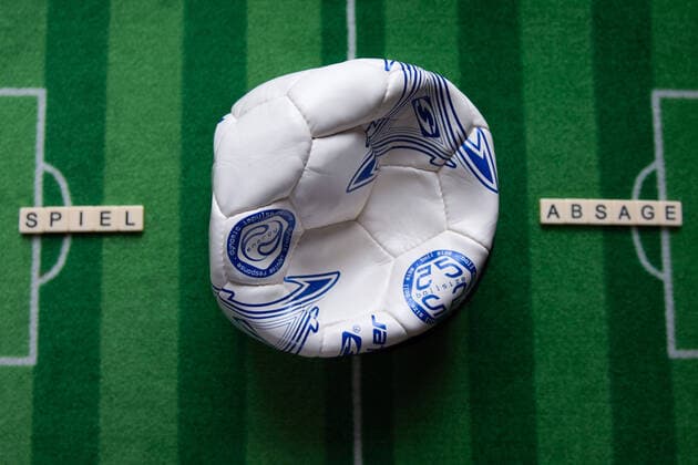 Deutschland 13.03.2020: Symbolbilder Coronavirus Das Coronavirus verursacht Veranstaltungsabsagen von Fußballspielen der Bundesligaprofiligen, Konzerte oder Schulen werden geschlossen. Hier: Ein kaputter Fußball mit dem Wort Spielabsage auf einem Fußballteppich. Deutschland