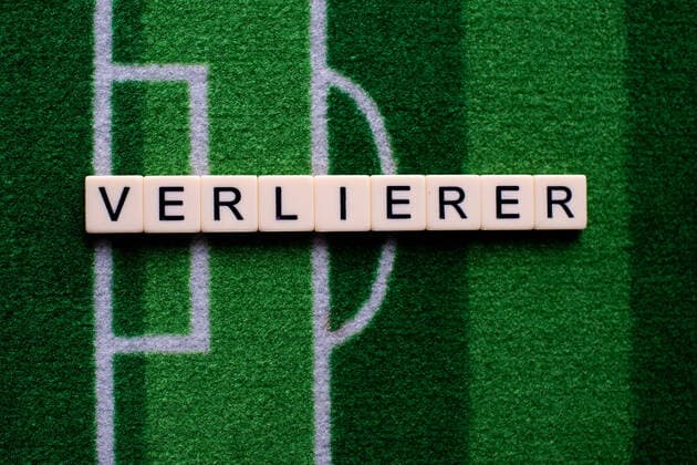 Das Coronavirus (Covid-19) verursacht Veranstaltungsabsagen von beispielsweise Fußballspielen der Bundesligaprofiligen auf unbestimmte Zeit und viele Auswirkungen, im Bild: Das Wort Verlierer auf einem Fußballteppich. Deutschland