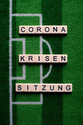 Das Coronavirus (Covid-19) verursacht Veranstaltungsabsagen von beispielsweise Fußballspielen der Bundesligaprofiligen auf unbestimmte Zeit und viele Auswirkungen, im Bild: Das Wort Corona Krisensitzung auf einem Fußballteppich. Deutschland