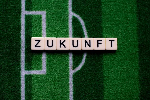 Das Coronavirus (Covid-19) verursacht Veranstaltungsabsagen von beispielsweise Fußballspielen der Bundesligaprofiligen auf unbestimmte Zeit und viele Auswirkungen, im Bild: Das Wort Zukunft auf einem Fußballteppich. Deutschland
