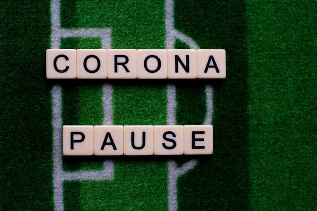 Das Coronavirus (Covid-19) verursacht Veranstaltungsabsagen von beispielsweise Fußballspielen der Bundesligaprofiligen auf unbestimmte Zeit und viele Auswirkungen, im Bild: Das Wort Corona Pause auf einem Fußballteppich. Deutschland