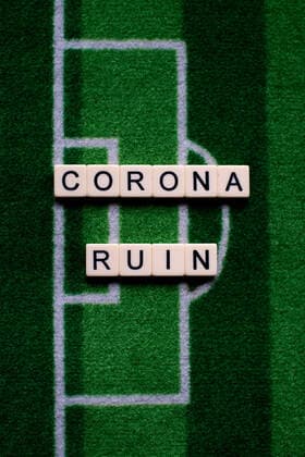 Das Coronavirus (Covid-19) verursacht Veranstaltungsabsagen von beispielsweise Fußballspielen der Bundesligaprofiligen auf unbestimmte Zeit und viele Auswirkungen, im Bild: Das Wort Corona Ruin auf einem Fußballteppich. Deutschland